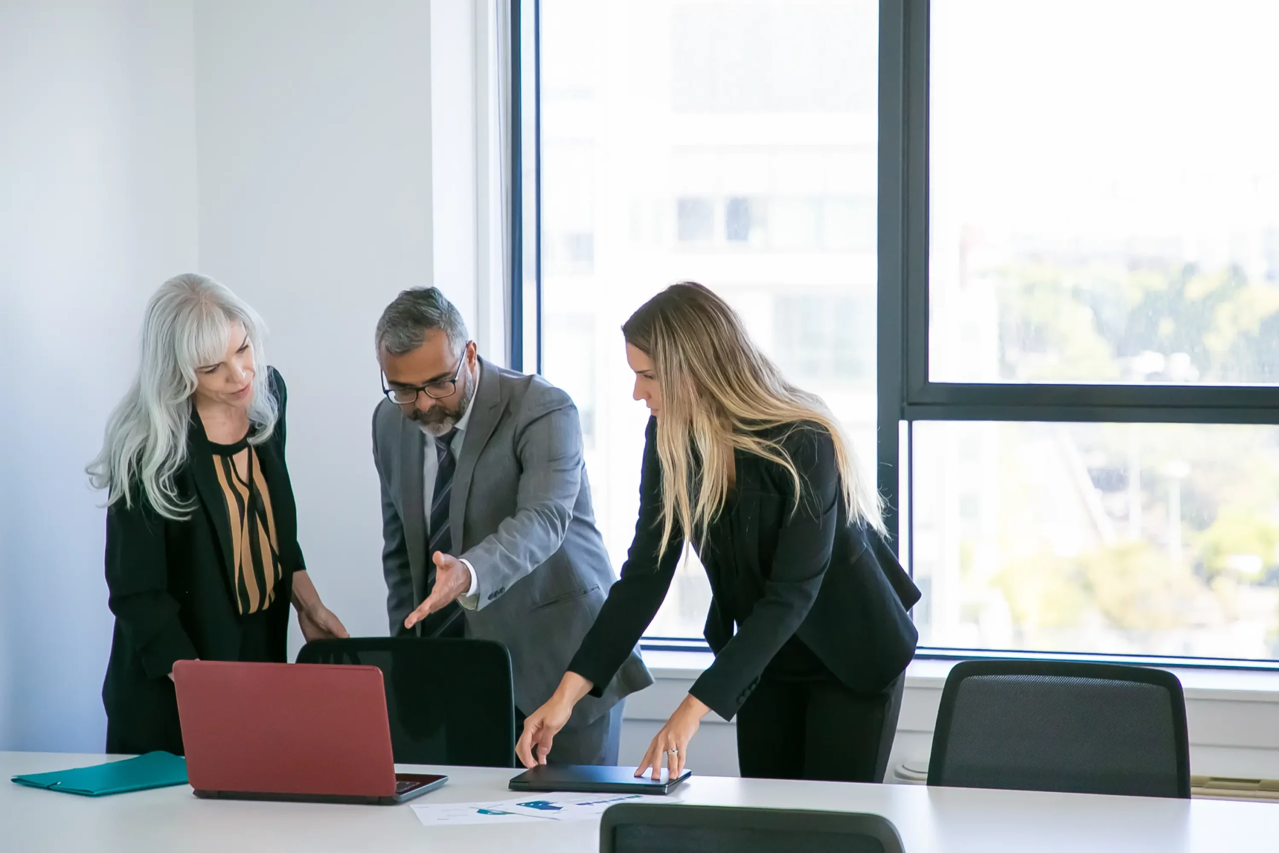 managers-showing-project-presentation-boss-businessman-pointing-hand-laptop-screen-talking-female-colleagues-wide-shot-business-communication-concept